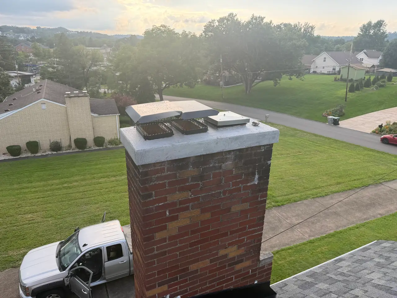 After repair: the same Canonsburg, PA chimney with a fresh waterproof crown coat, two new caps over the smaller flues, and a top-mount damper on the large flue
