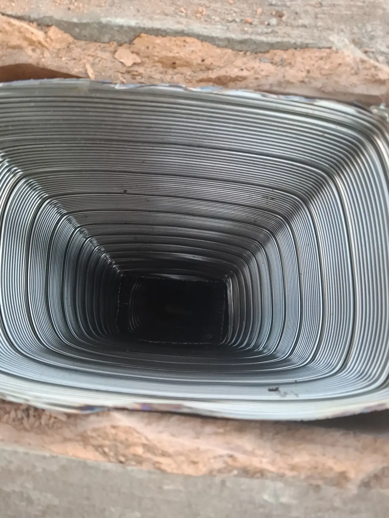 Straight down the inside of the new flexible stainless steel chimney liner from the top of the Allison Park, PA fireplace flue